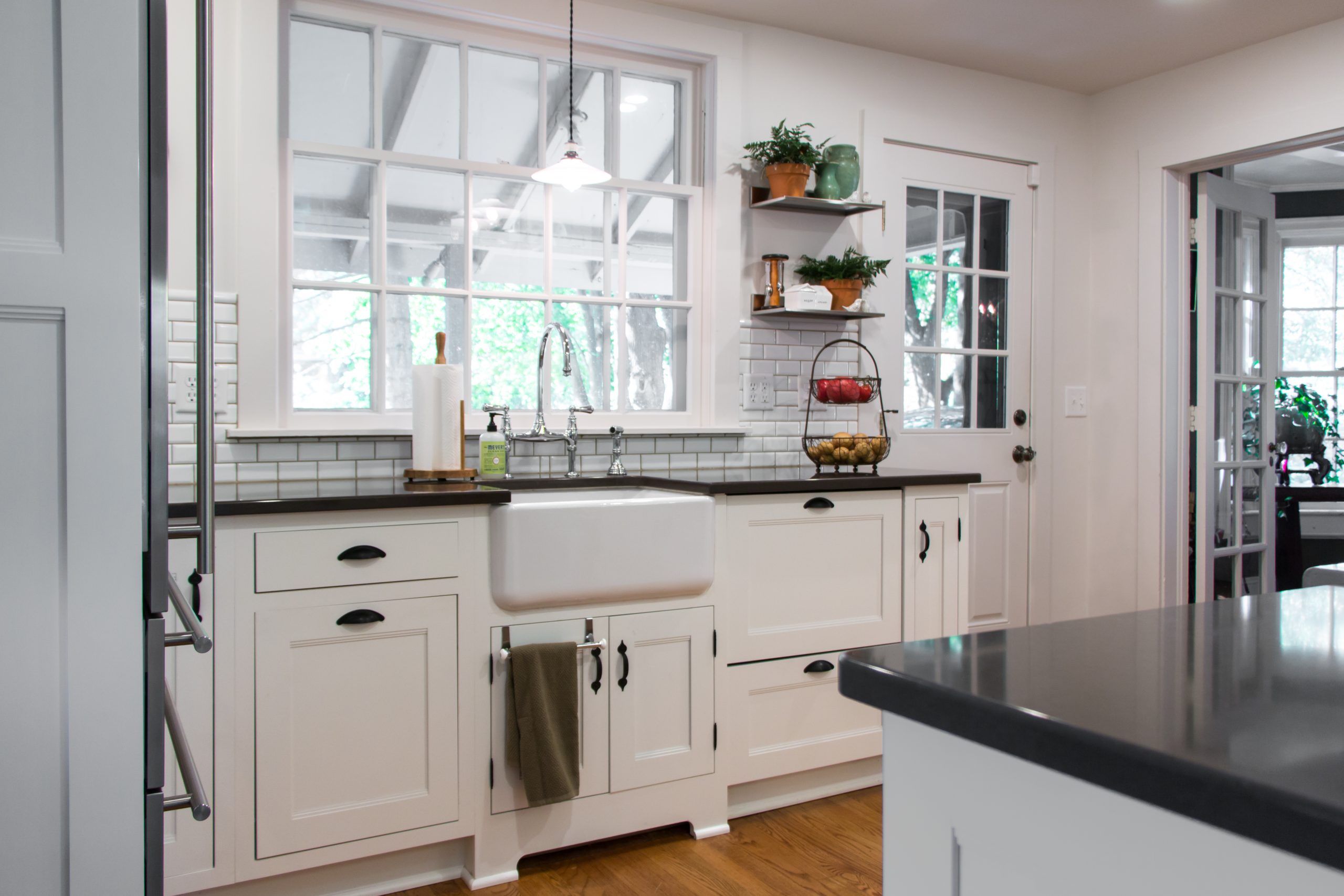 Elegant farmhouse kitchen and bath remodel with white cabinets and hardwood floors