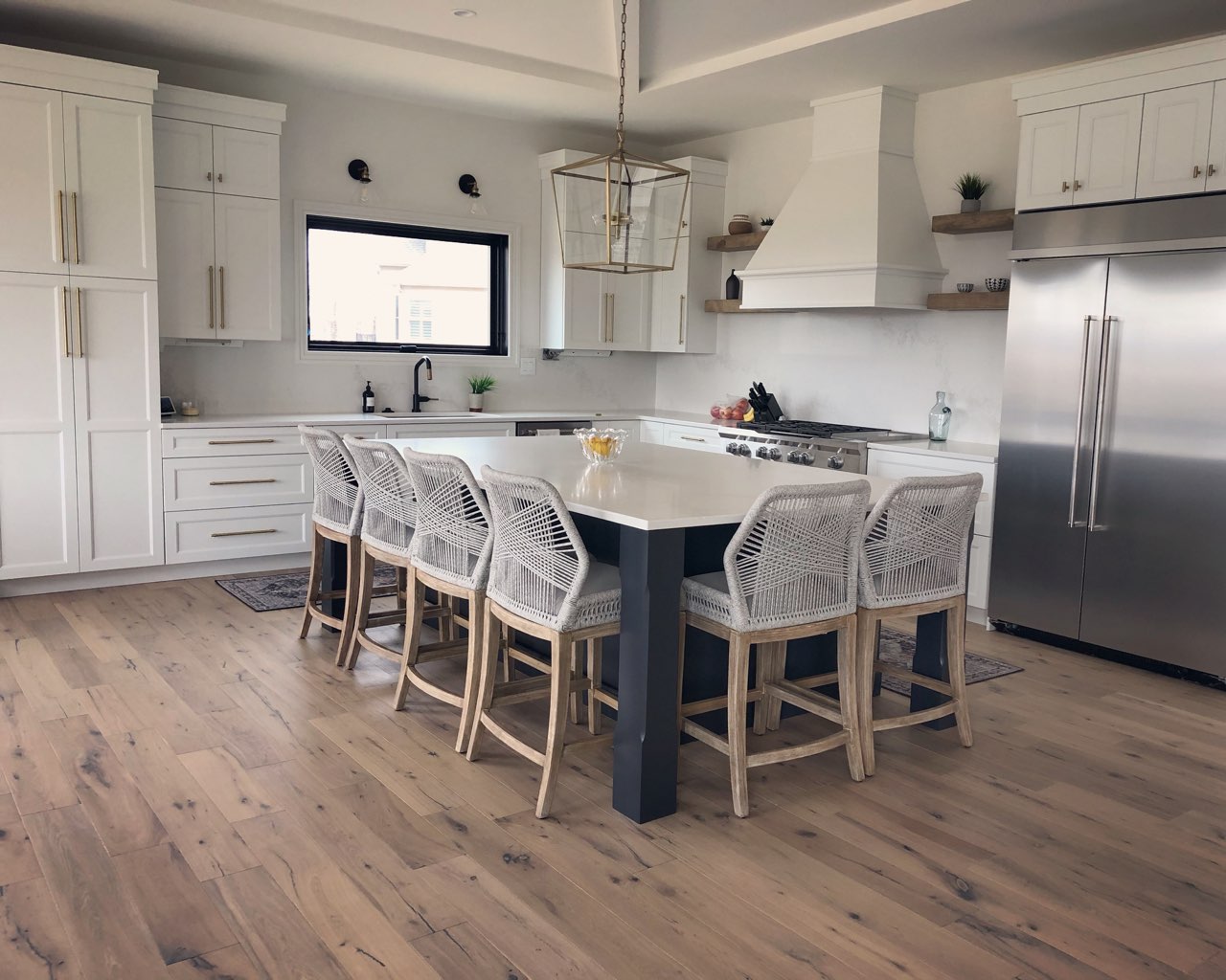 kitchen design project featuring white quartz island, hardwood flooring and white cabinetry