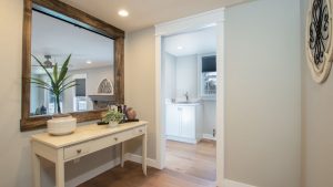 Hallway in a home design project with hardwood flooring and white painted buffet table