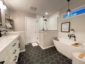 bath remodel with charcoal grey hexagon floor tile and a white porcelain freestanding tub