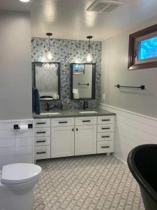 blue mosaic wall tile and white vanity cabinets