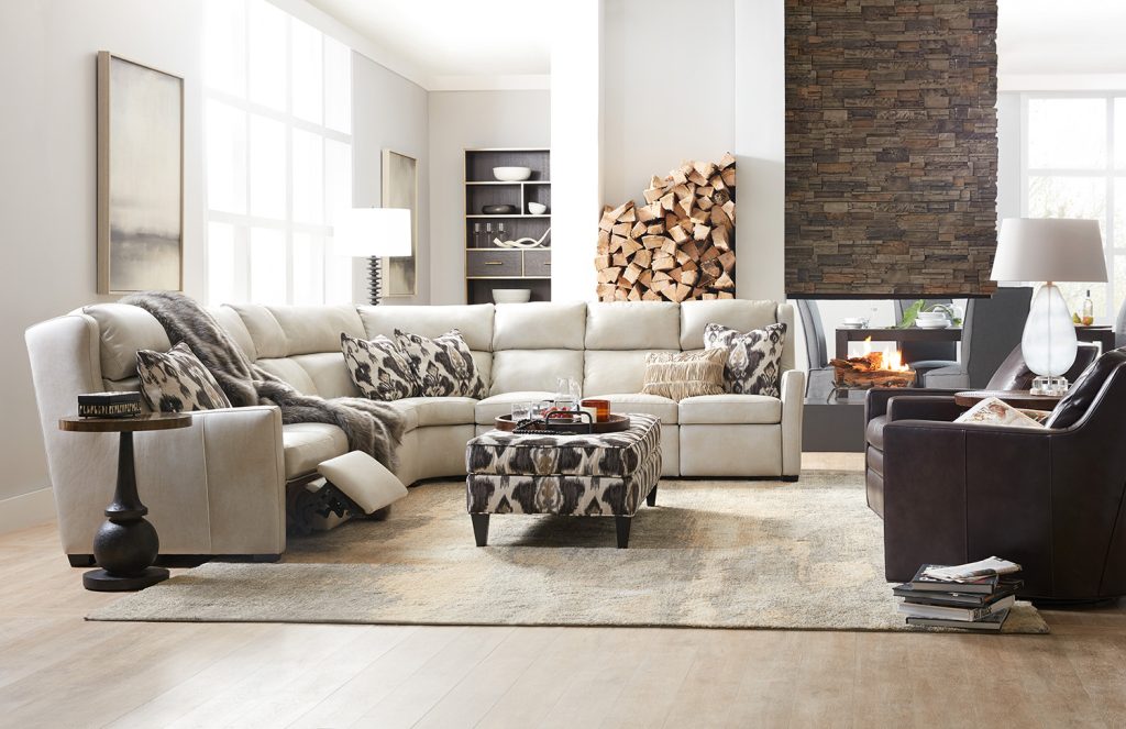 Cozy fall living room furniture set with white leather sectional and kantha patterned ottoman