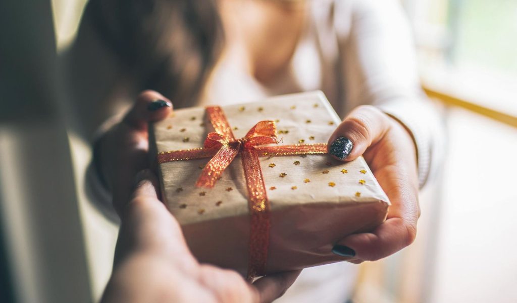 woman giving a hand-wrapped benson stone co gift