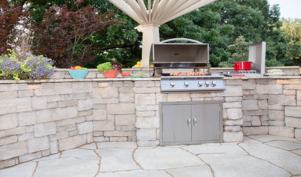 Outdoor kitchen design with stone and built in gas grill 