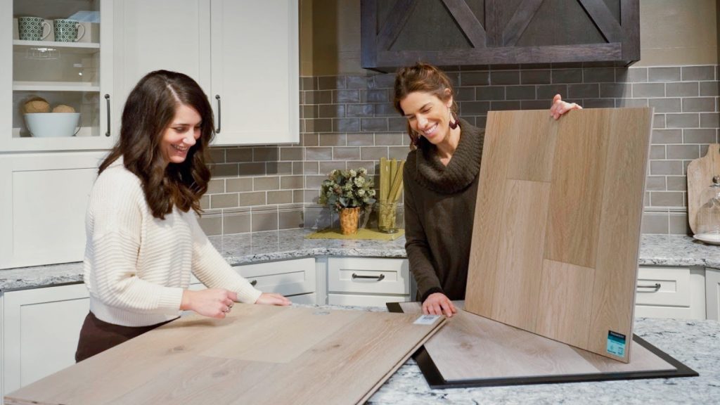 Woman shopping for luxury vinyl with a designer in the flooring showroom