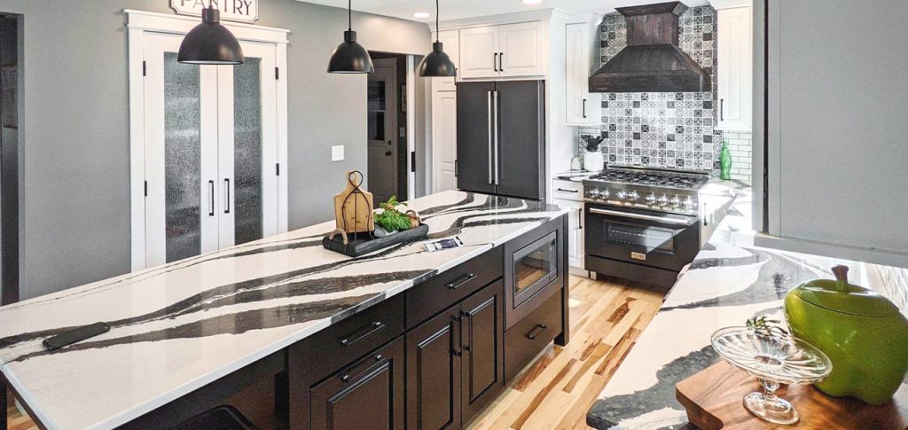 Eclectic kitchen design with bold black & white granite countertops, black cabinets, and painted tile backsplash
