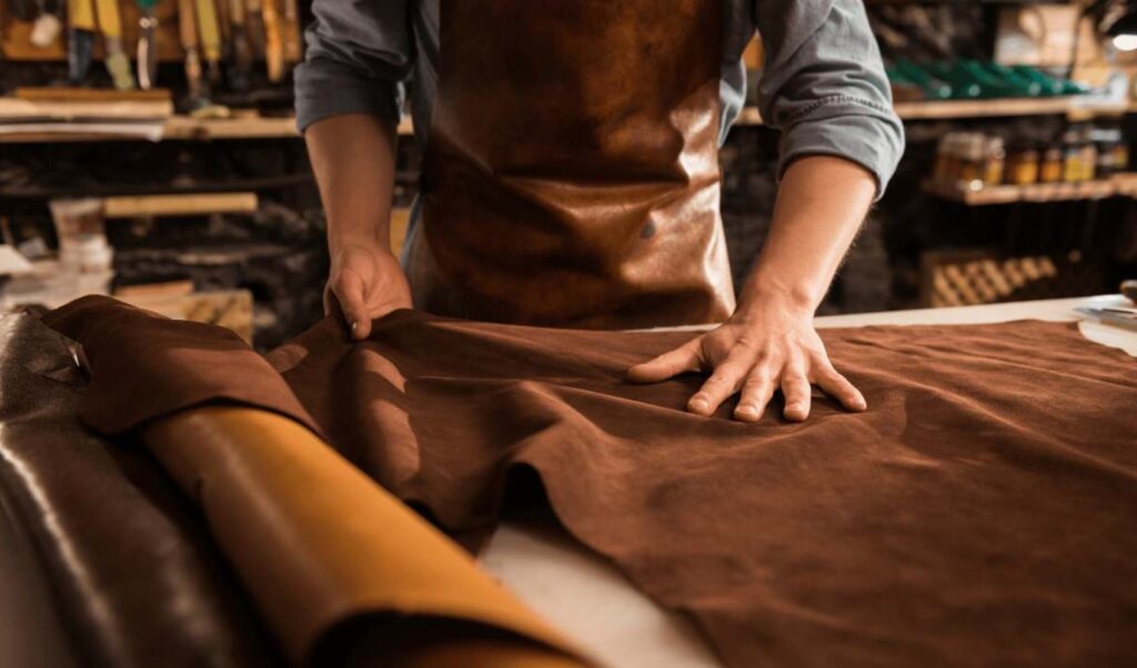 craftsmen cutting leather for furniture