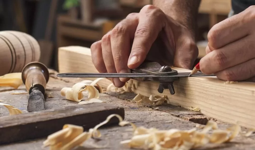 furniture craftsman carving wood in his shop