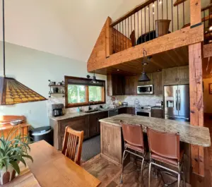 rustic kitchen design near rockford, il with reclaimed barnwood beams, knotty alder cabinets, and leathered granite countertops