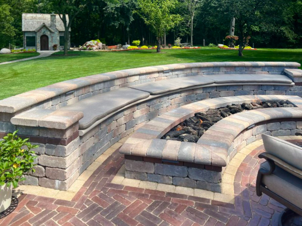 outdoor living space with paving brick patio and curved gas firepit, built with products from benson stone company in rockford, il