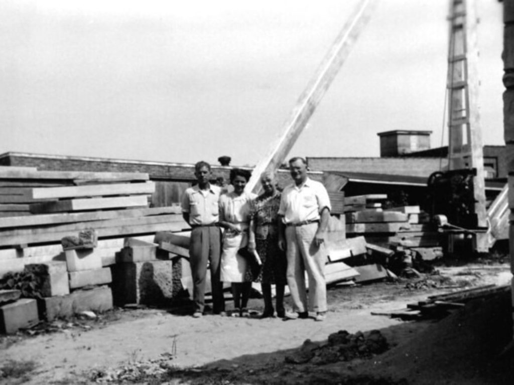 Black and white photo of the first and second generations of the Benson Stone Company family business, standing in the stone yard in the 1950's