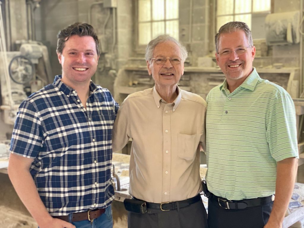 Photo of the third, fourth, and fifth generations of our family business standing in the stone cutting shop 